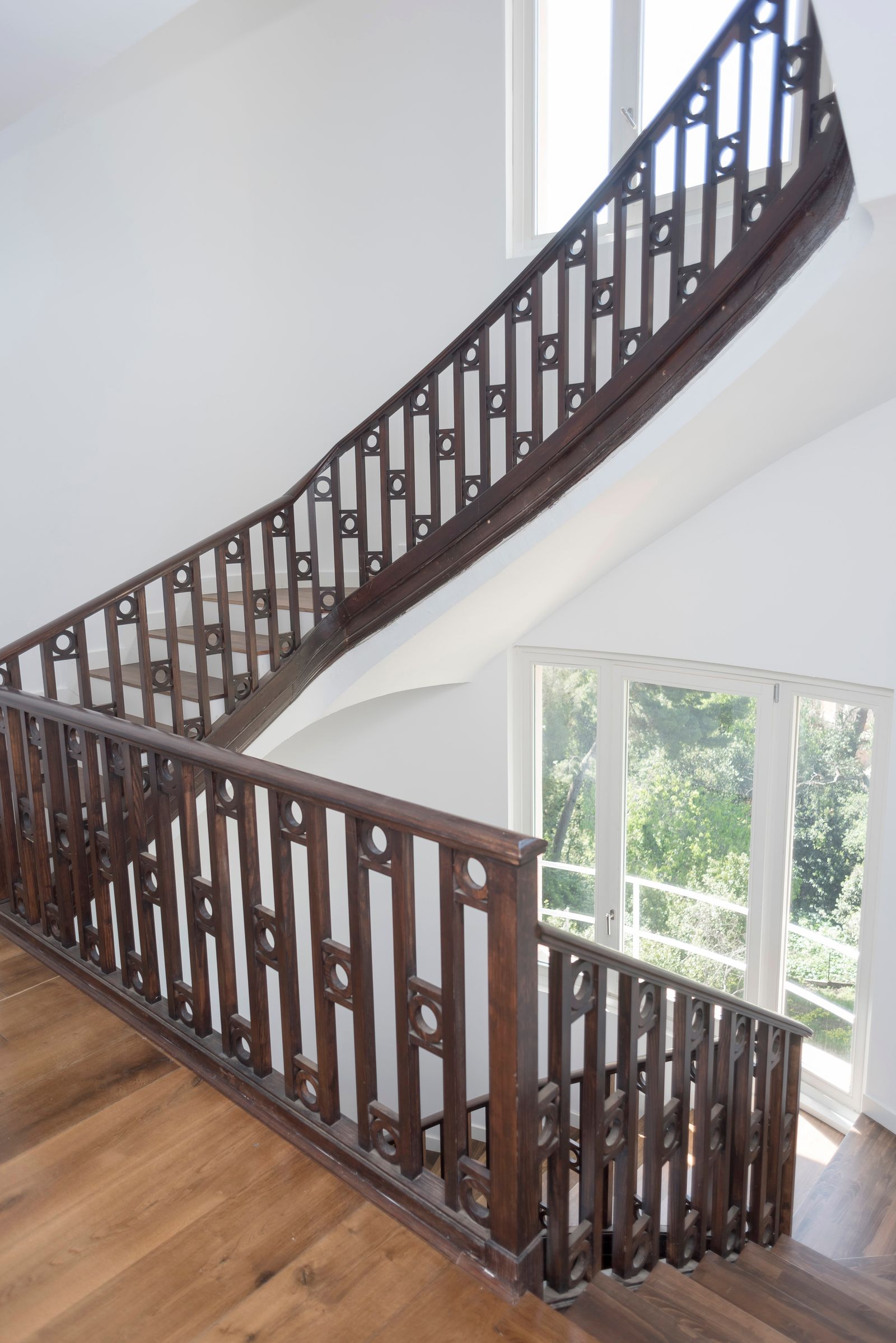Dark wood staircase railing with carved detail